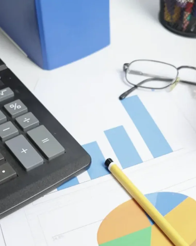 Calculator, financial reports and bookkeeping records on an office desk